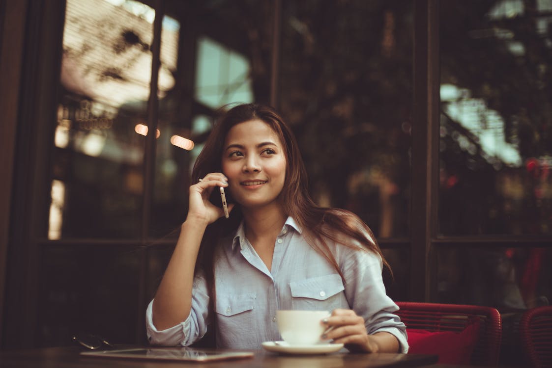 무료 카페에서 휴대 전화를 사용 하여 젊은 여자의 초상화 스톡 사진
