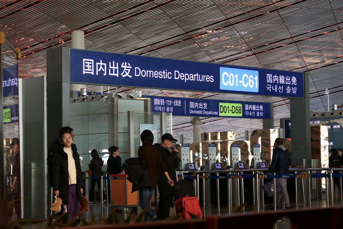 Departure screens in an airport terminal showing flight status
