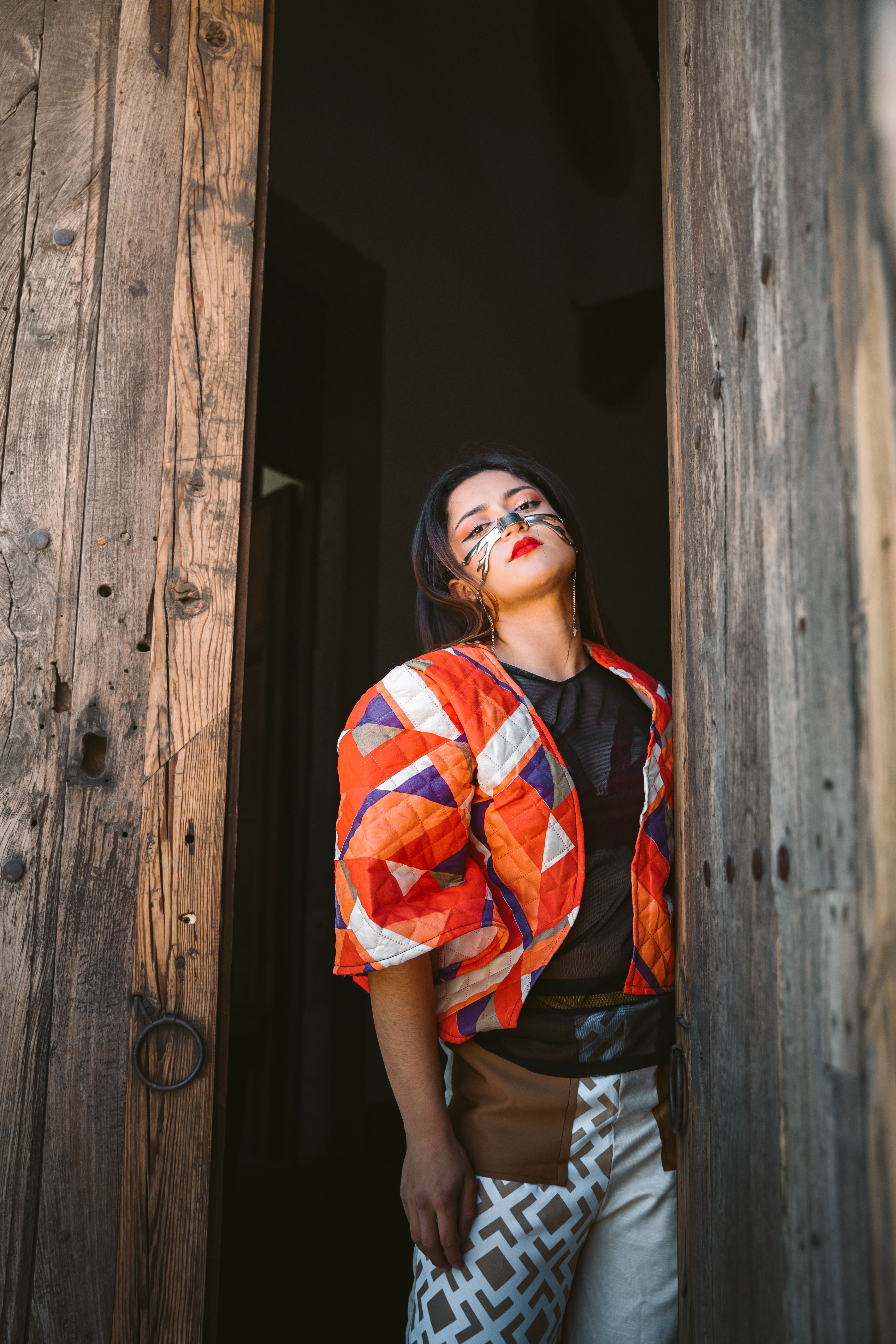 Fashionable Woman Posing in Rustic Wooden Doorway · Free Stock Photo