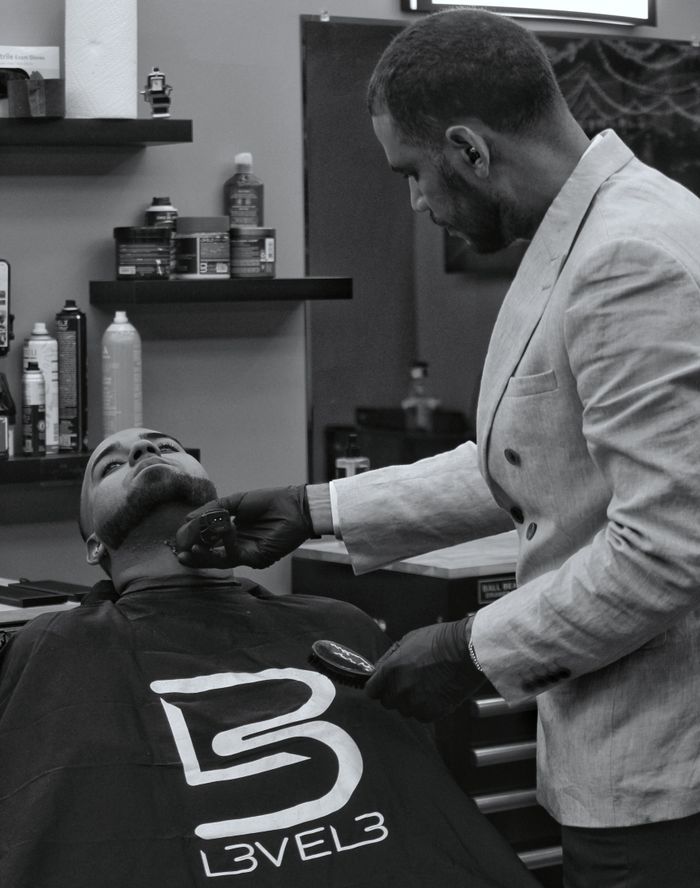 Barber shaving client inside a barbershop