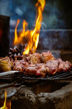 Close-up of sizzling grilled meat with vibrant flames, perfect for BBQ themes.