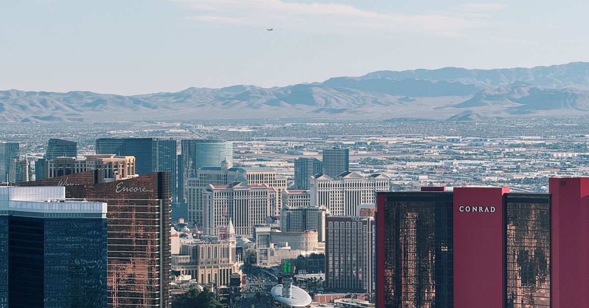 Stunning aerial photo of Las Vegas Strip with distant mountains under clear blue sky.