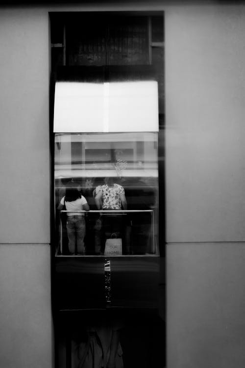 Fotografi Grayscale Orang Di Dalam Elevator
