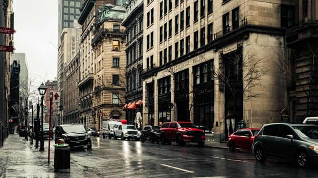 Capture of Rue Saint-Jacques in Montreal with classic architecture and wet streets.
