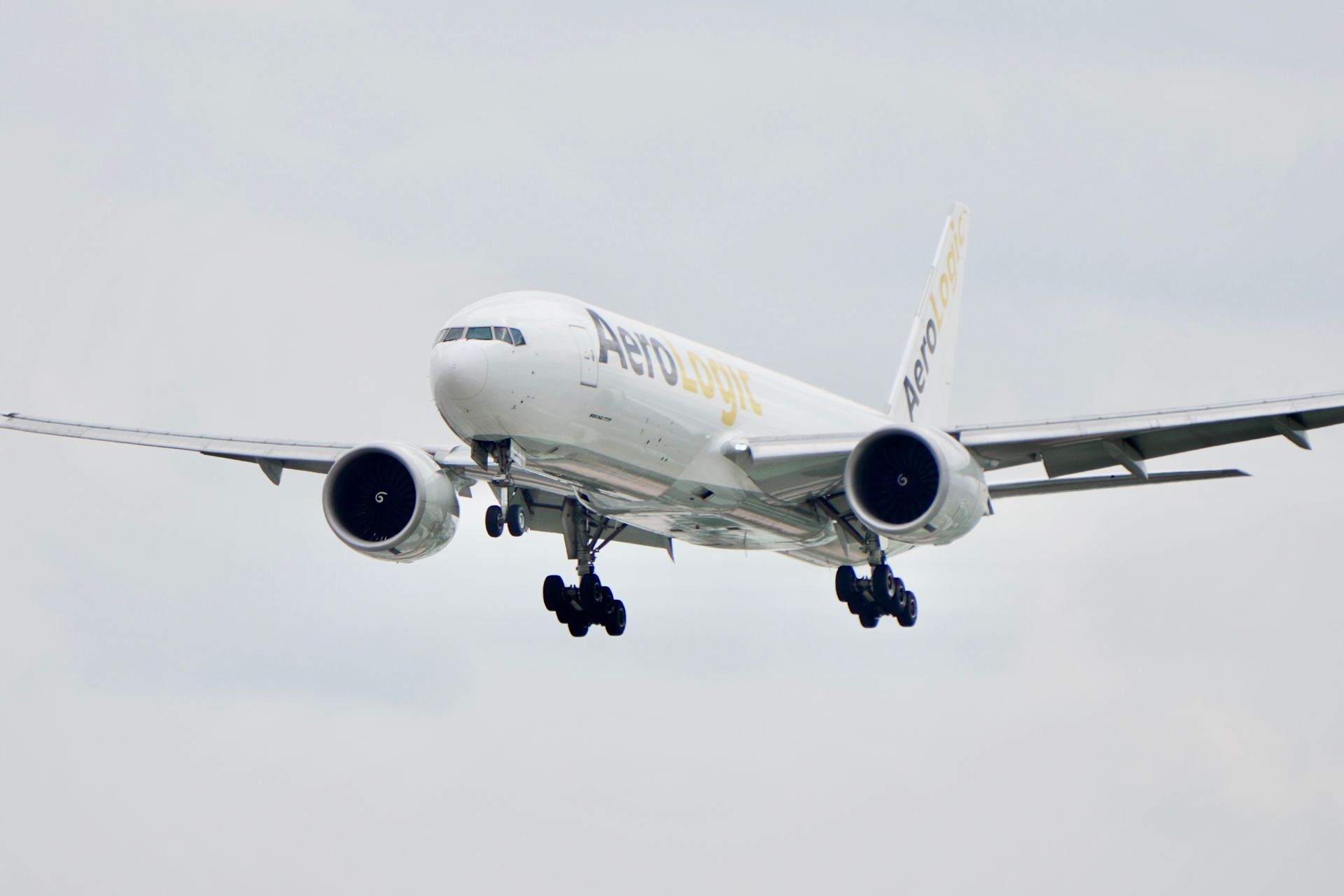AeroLogic cargo aircraft approaches landing under a clear sky, showcasing aviation dynamics.