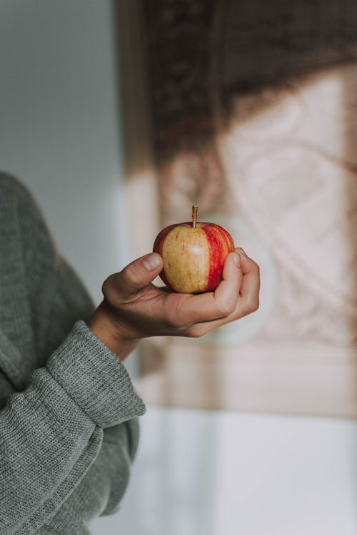 Selective Focus Photo Holding Apple Fruit