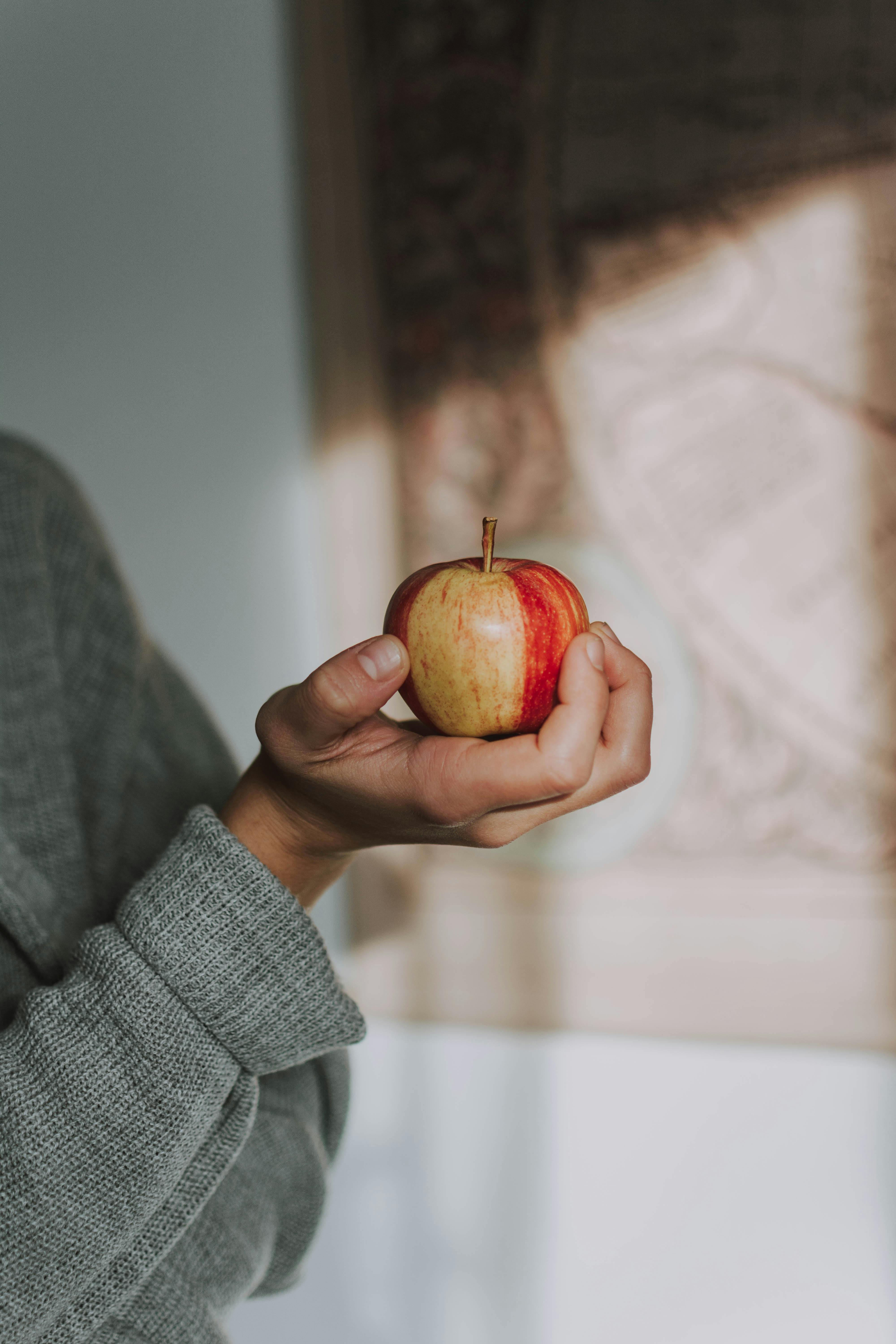 Selective Focus Photo Holding Apple Fruit · Free Stock Photo