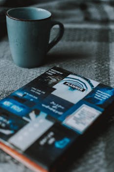 柔软的床单上，蓝色马克杯和彩色计划片摆放着，营造出舒适的氛围