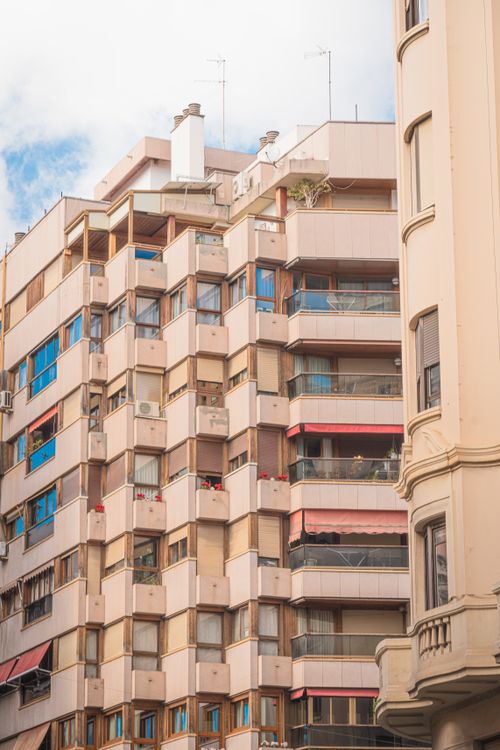 Free View of high-rise urban apartments with various balconies under a clear blue sky. Stock Photo