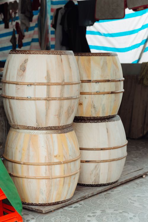 Free Four wooden barrels stacked in an outdoor market stall with striped awnings. Stock Photo