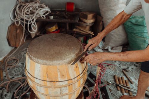 Free A skilled craftsman working on a traditional drum, showcasing artisanal woodworking techniques. Stock Photo