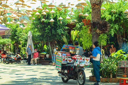Free Lively outdoor market scene with a food vendor and colorful hanging lanterns in an urban setting. Stock Photo