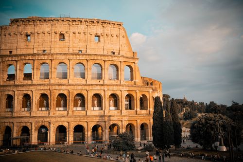 Free The majestic Colosseum in Rome captured at sunset with a warm, inviting glow. Stock Photo