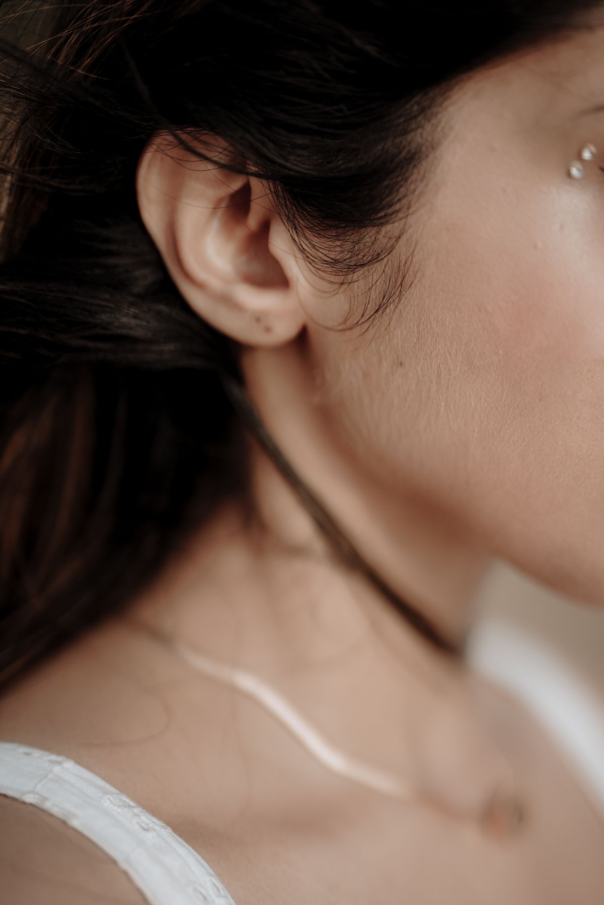 A fine chain worn at the collarbone, shot close