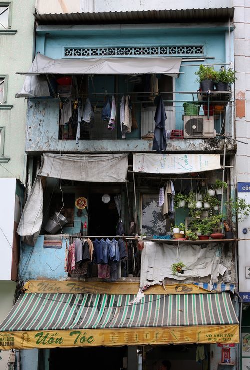 Free Urban balcony scene in a densely packed city, featuring hanging laundry and potted plants. Stock Photo