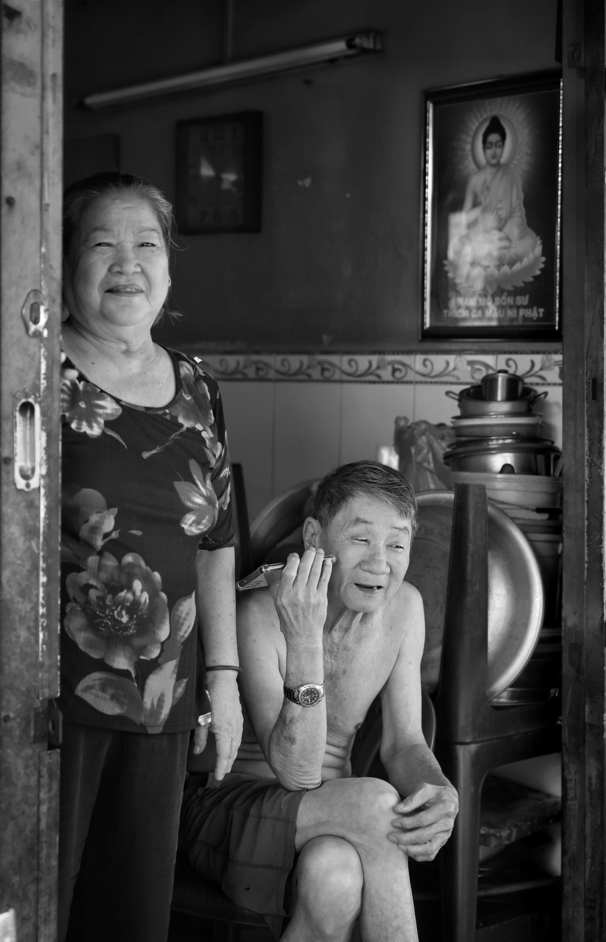 An elderly Asian couple resting together inside their home