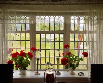 Charming cabin interior in Eggedal, Norway featuring vintage decorations and red geraniums.