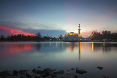 Free Beautiful mosque reflecting on serene lake at dusk with vibrant sky colors. Stock Photo