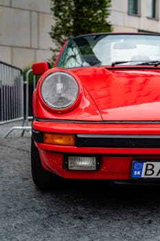 Front view of a vintage red sports car parked on a city street in Bratislava.
