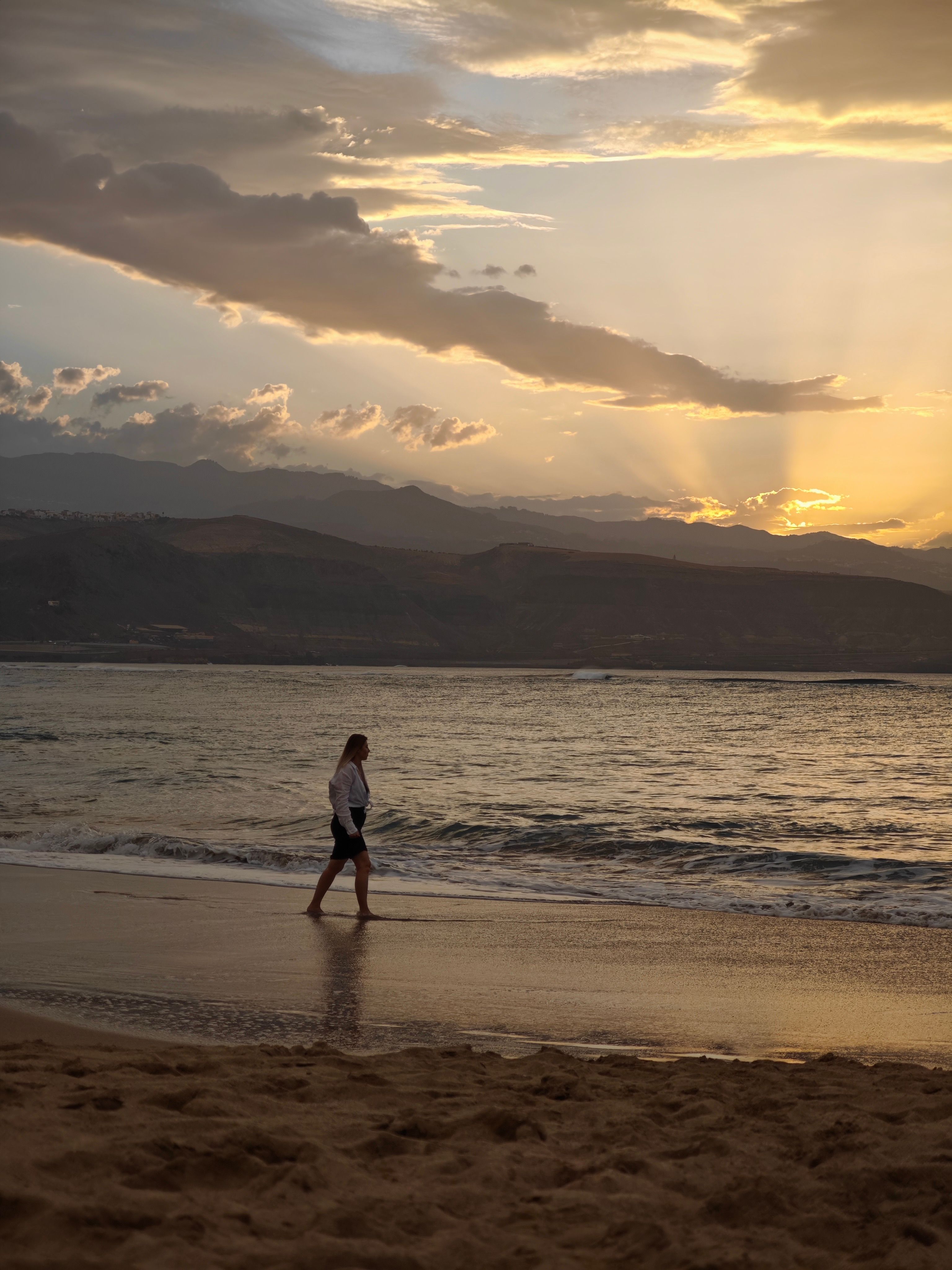 Silhouette of a Woman Walking on Beach at Sunset · Free Stock Photo