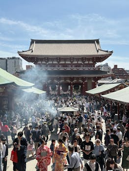 A bustling crowd at the historic Sensō-ji Temple in Tokyo on a sunny day.