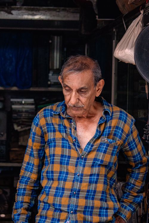 Free Candid portrait of an elderly man in a plaid shirt, embodying wisdom and life experience. Stock Photo