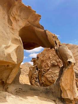 Dramatic stone arch formation in Isole Canarie, Spain under a clear blue sky.