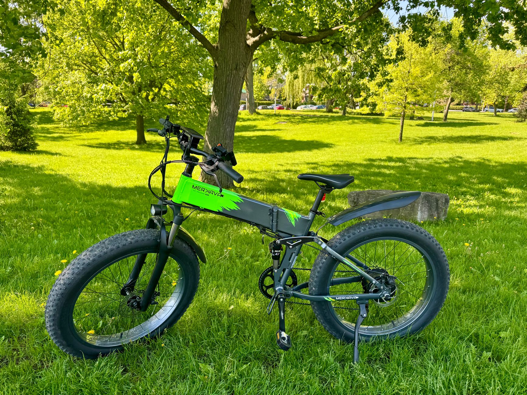 Electric mountain bike in a sunlit park, Montreal, showcasing eco-friendly transportation.