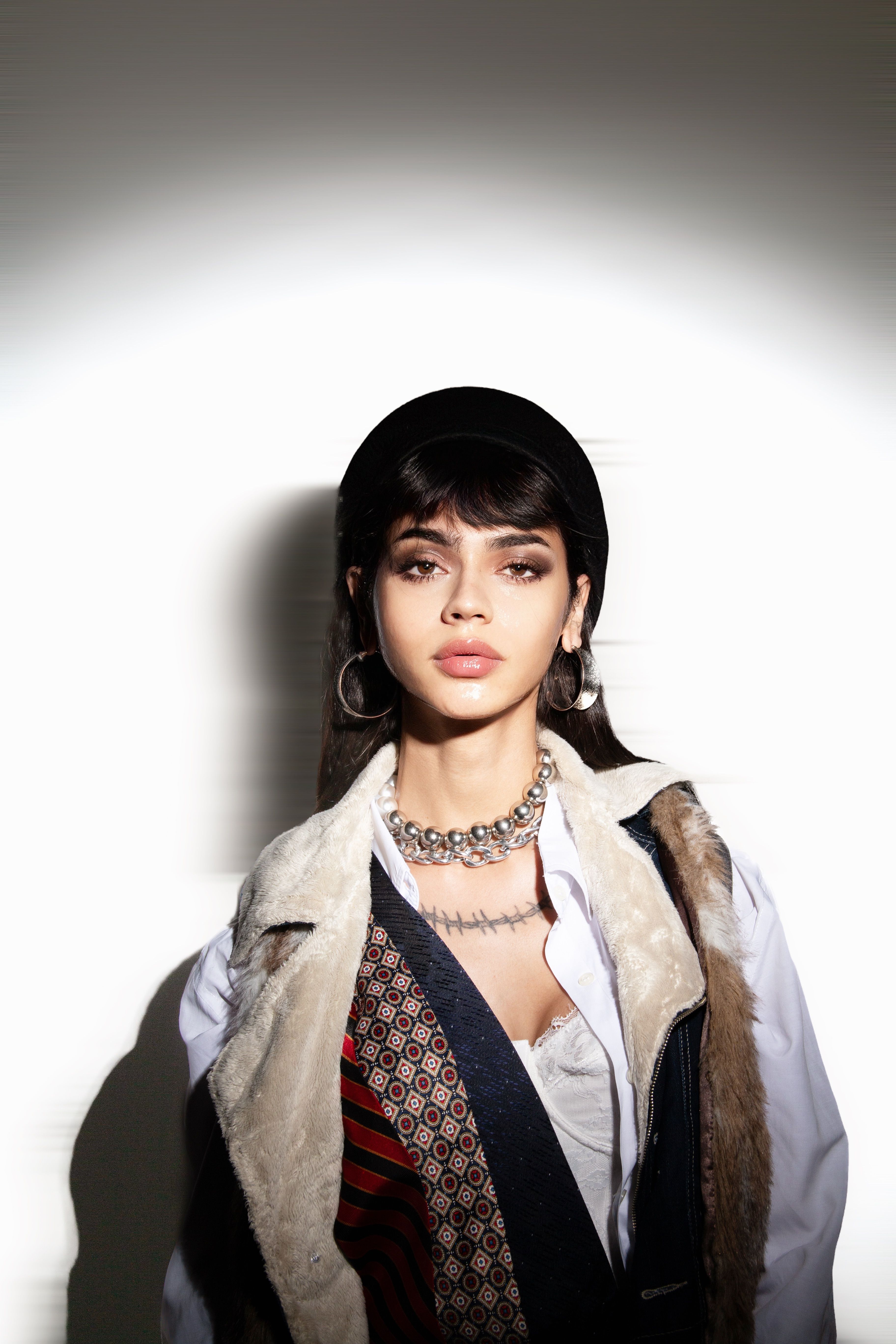 Stylish woman in fur vest and accessories in São Paulo photography studio.