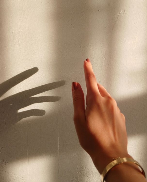 Hand Reaching for Shadow on Sunlit Wall · Free Stock Photo
