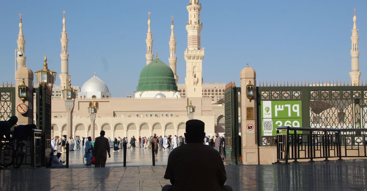 Rüyada Hac Yaptığını Görmek - Rüya Tabiri ve Anlamı - Suudi Arabistan'ın Medine kentindeki Mescid-i Nebevi'nin önünde oturan bir kişinin silüeti.