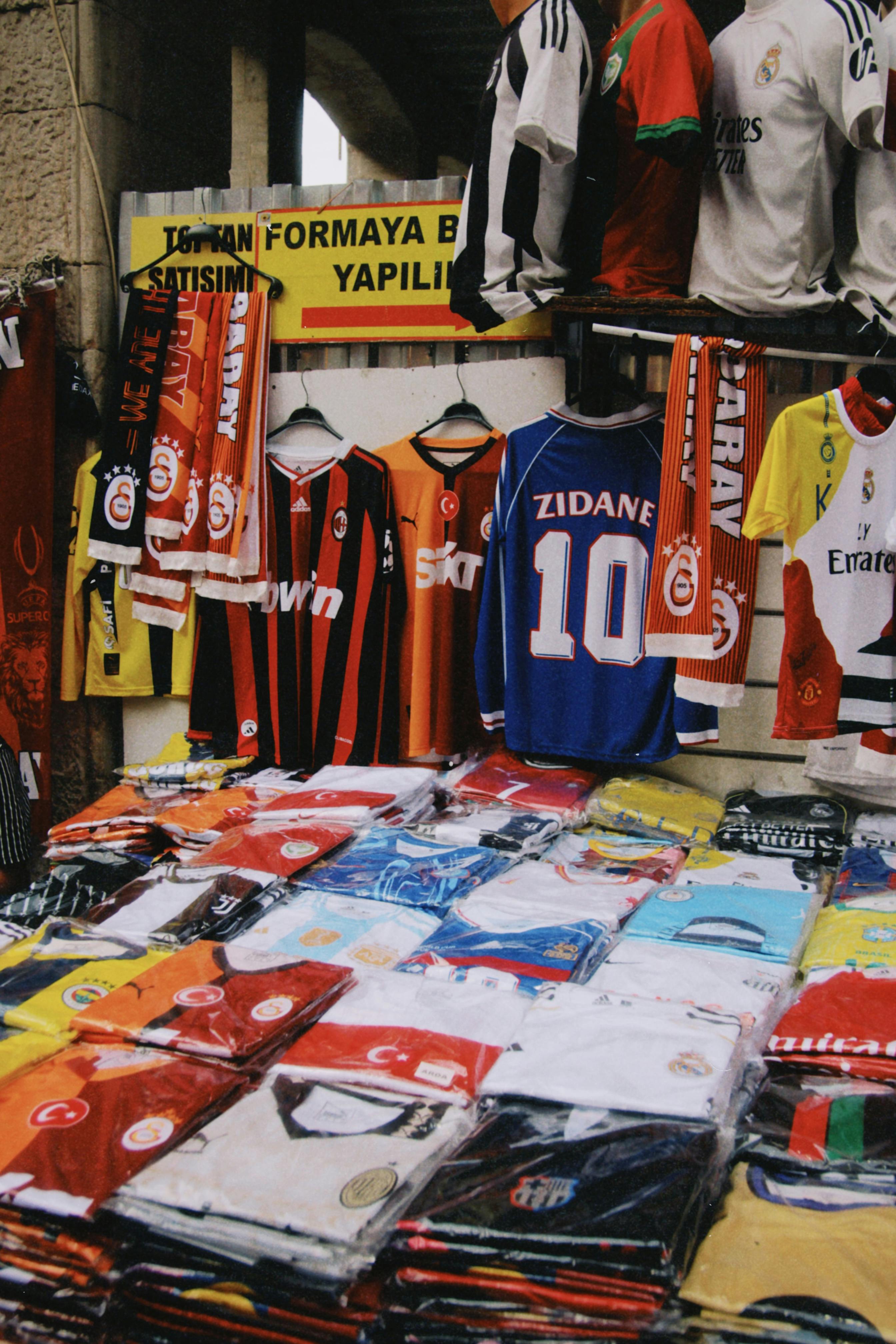 colorful soccer jerseys on display at market stall