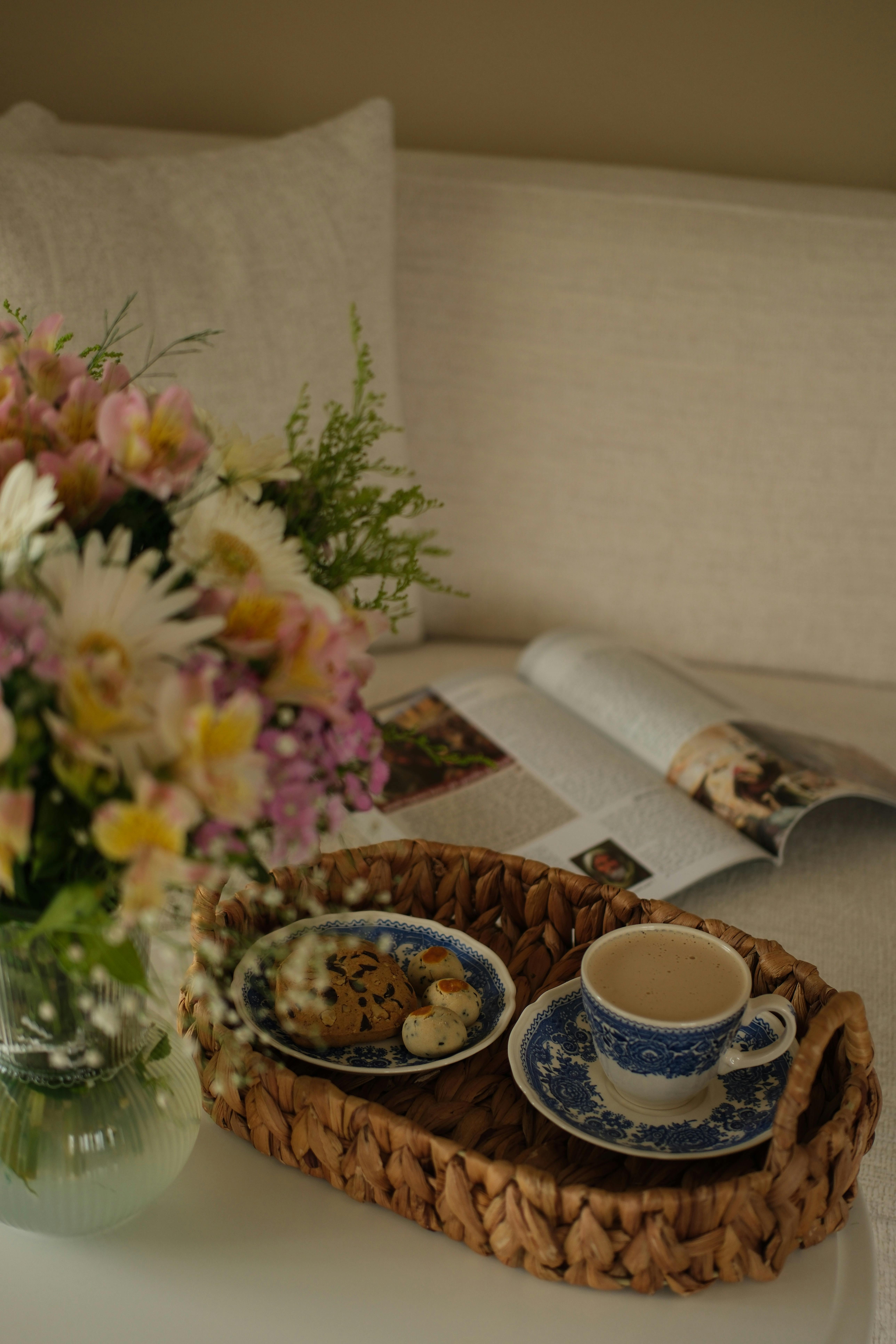 A cozy morning scene with coffee, cookies, and a fresh flower bouquet.