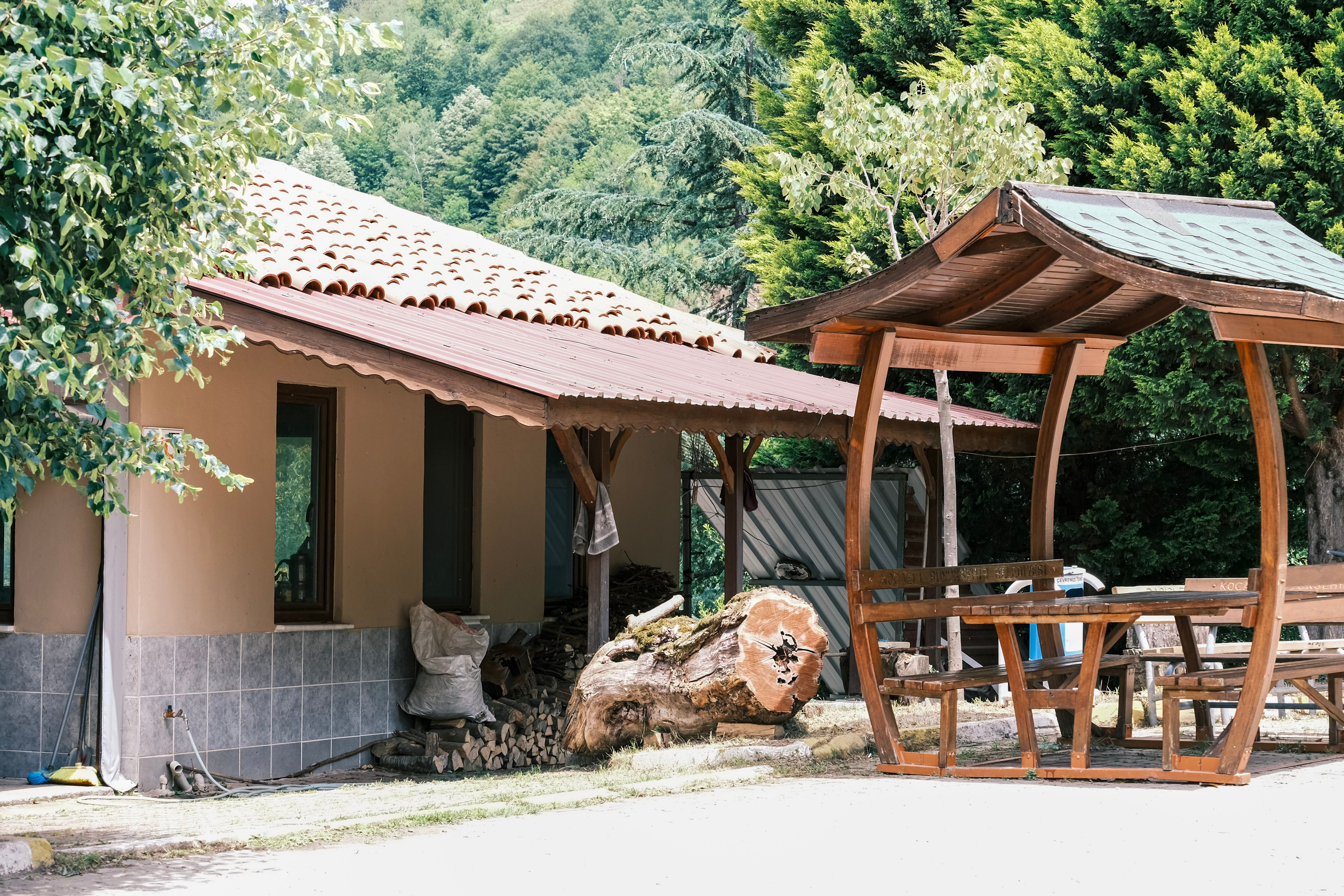 Rustic House with Wooden Gazebo in Forest Setting · Free Stock Photo
