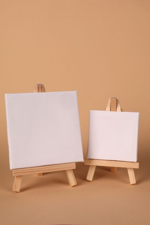 Free Two blank canvases on wooden easels against a neutral background, perfect for art projects. Stock Photo
