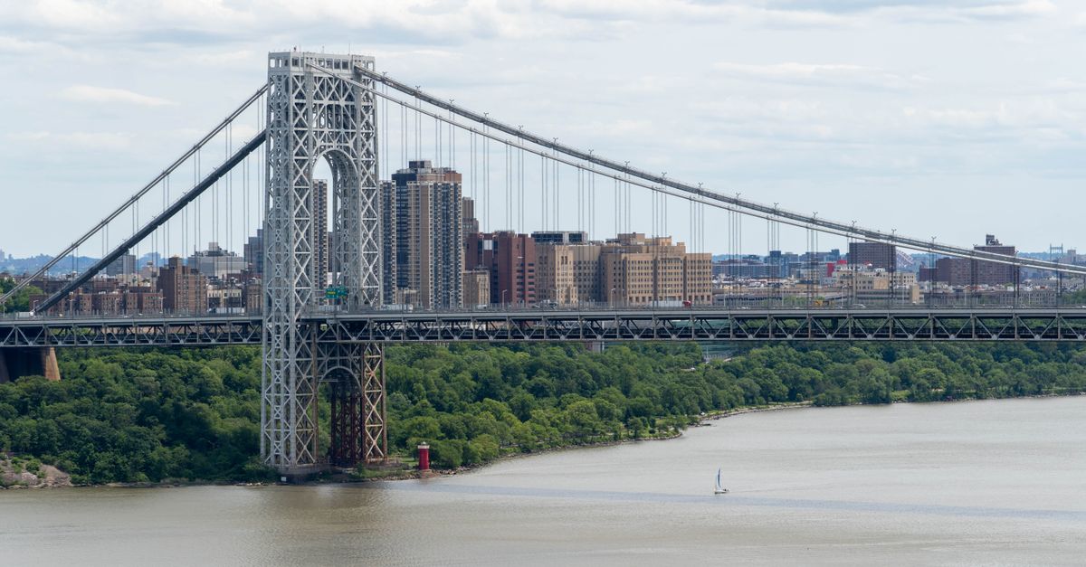 Stunning view of George Washington Bridge spanning the Hudson River with Manhattan cityscape backdrop.