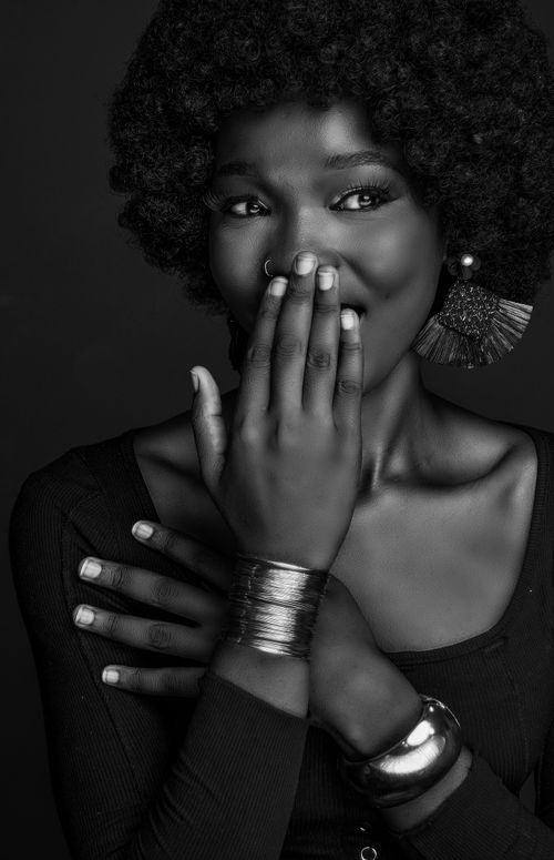 Free Black and white portrait of a woman with curly hair and jewelry, exuding elegance. Stock Photo