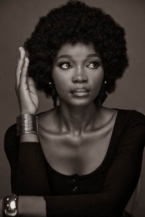Free Stunning sepia-toned portrait of a woman with afro hair and stylish accessories. Stock Photo