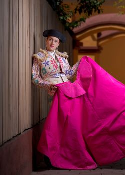 Colorful portrait of a matador in traditional bullfighting costume holding a cape.
