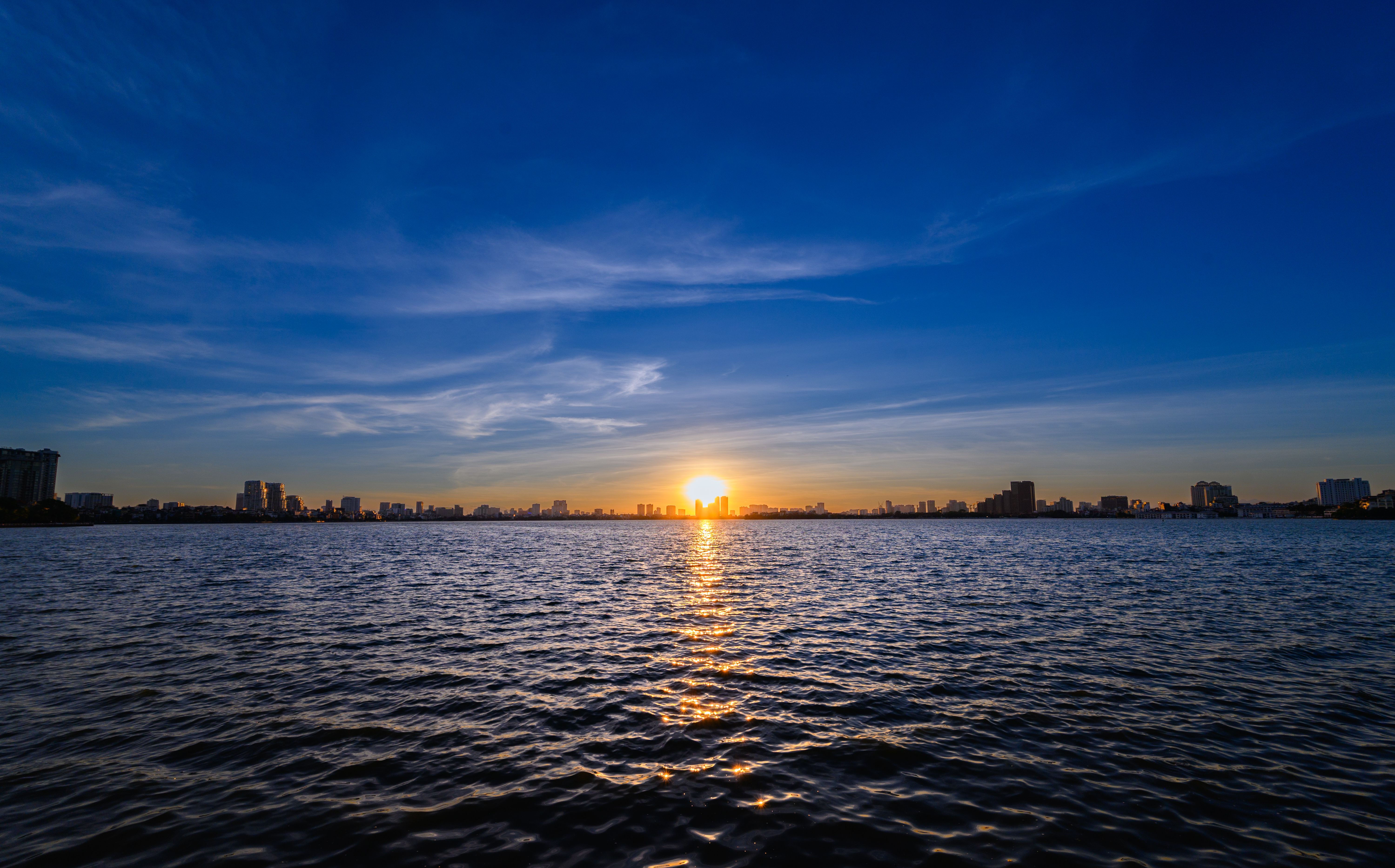 Vibrant Sunset Over Urban Waterfront Skyline · Free Stock Photo
