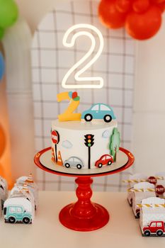 Charming car-themed cake with number 2 topper, perfect for a child's second birthday celebration.