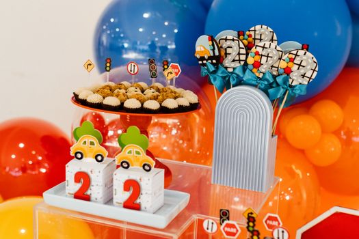 Colorful second birthday party setup with traffic theme decor and sweets.