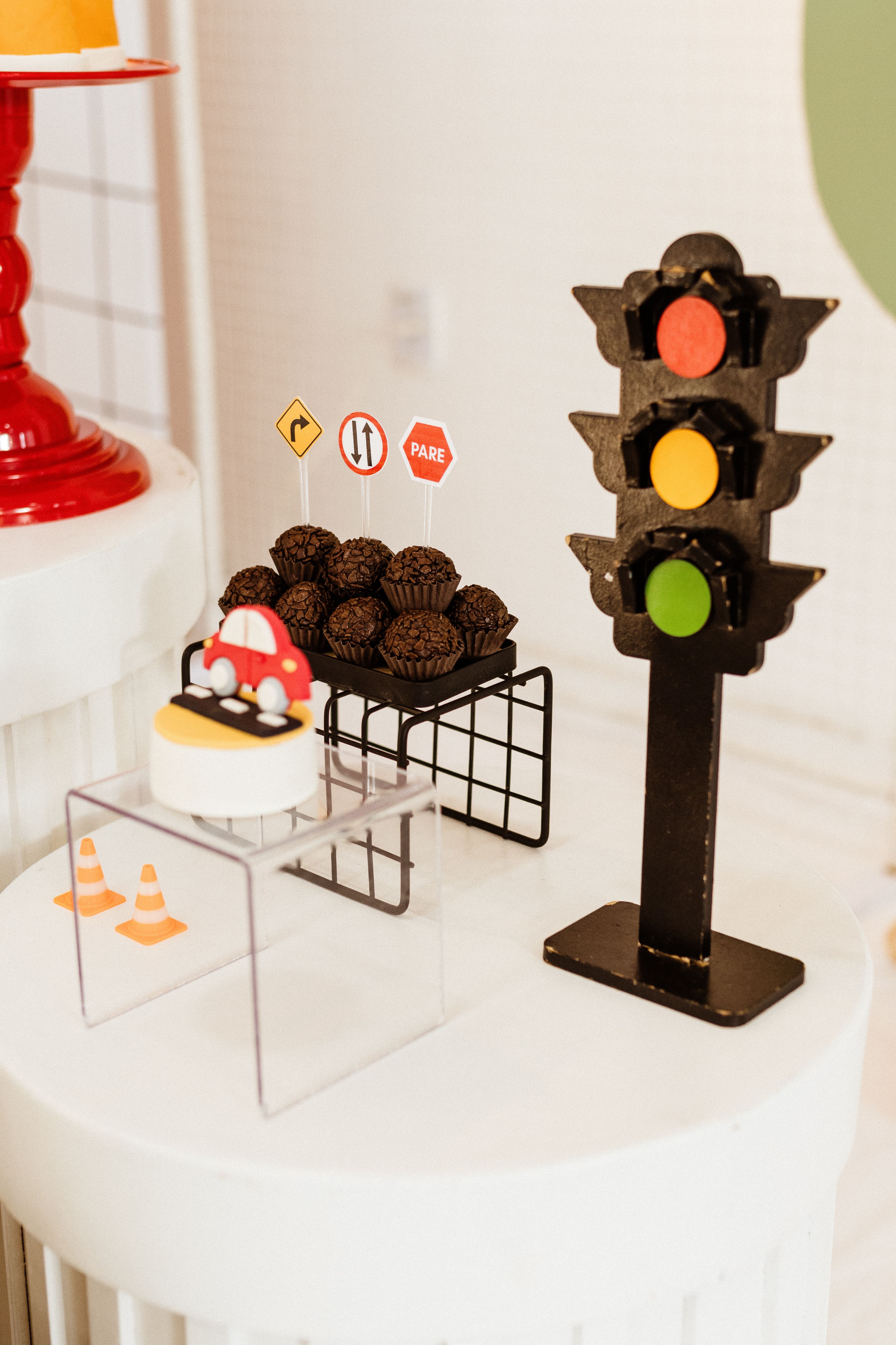 Traffic-themed dessert table with cakes, cupcakes, and semaphore lights decor.
