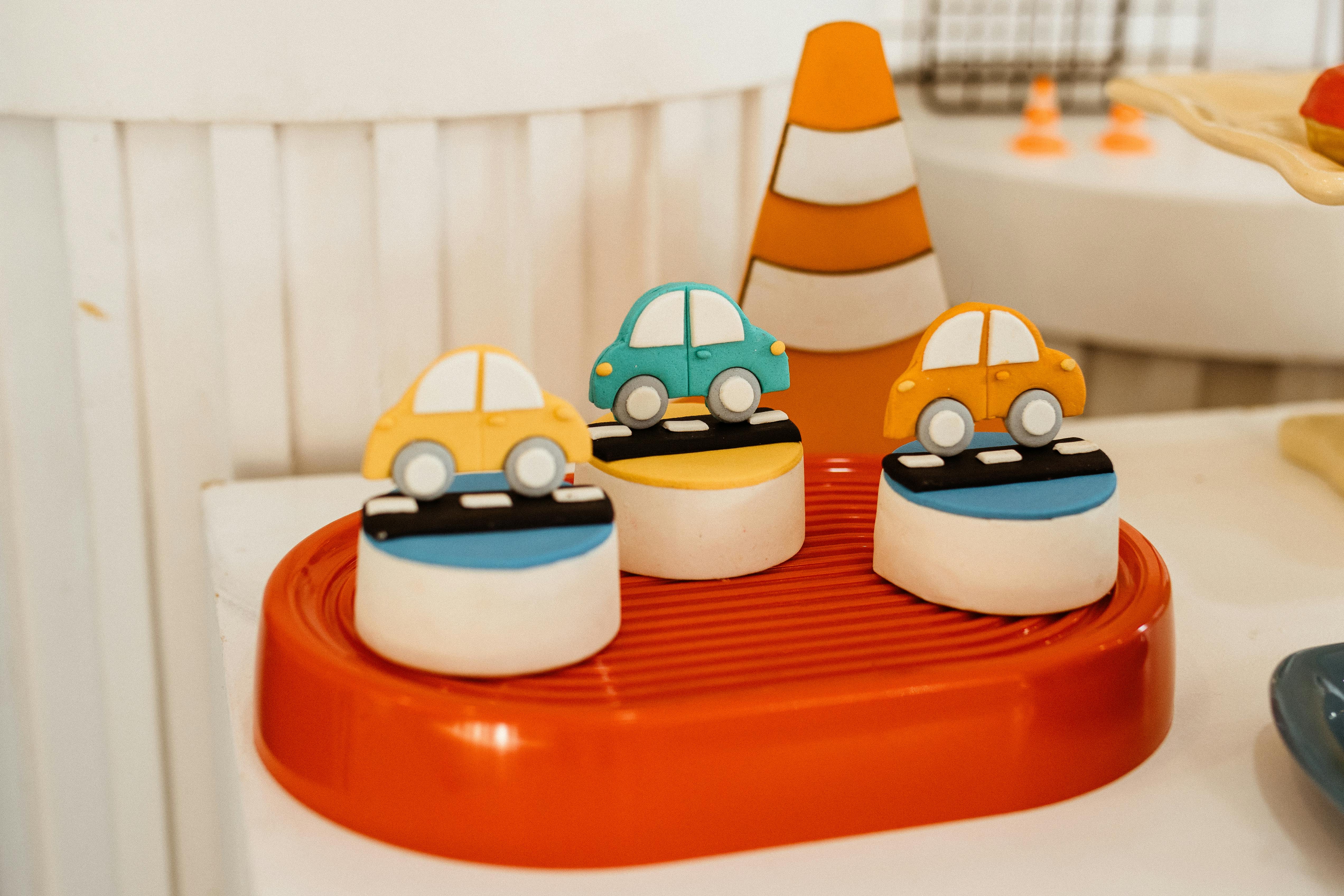 Bright display of colorful toy cars on a decorative platform, perfect for children's party themes.