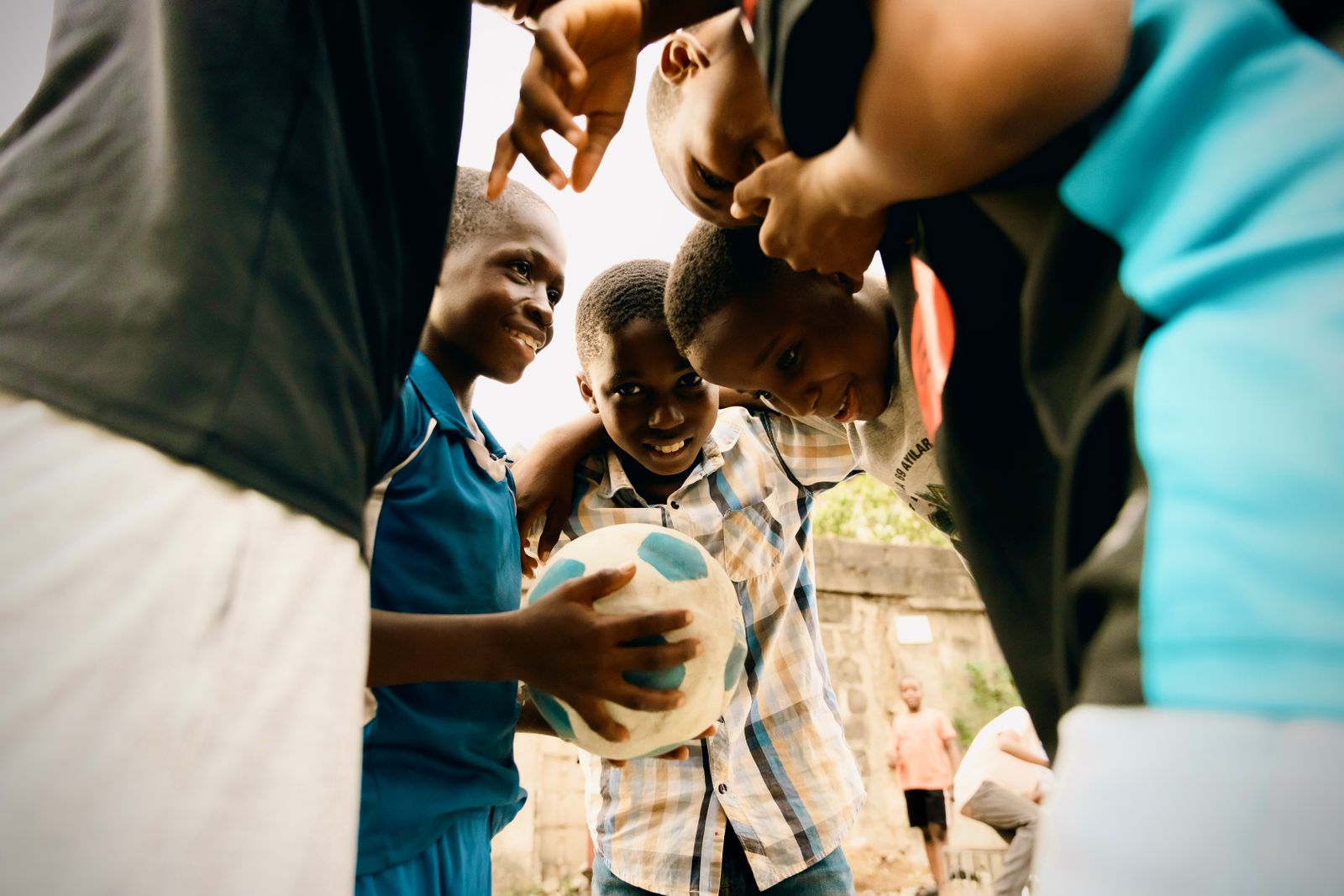 A group of boys joyfully playing a football match outdoors