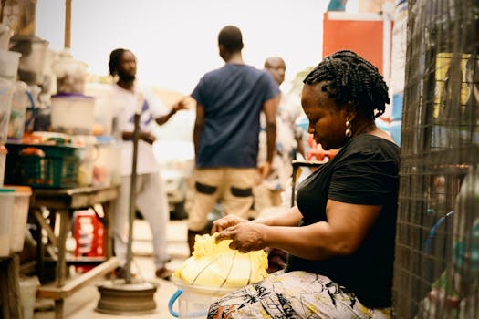 A woman prepares goods in a bustling street market environment, showcasing daily trade and interactions.