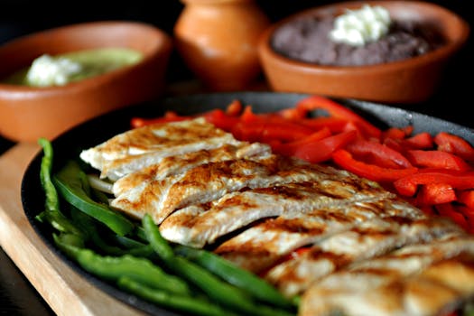 Delicious grilled chicken fajitas with bell peppers, served with traditional Mexican sauces.