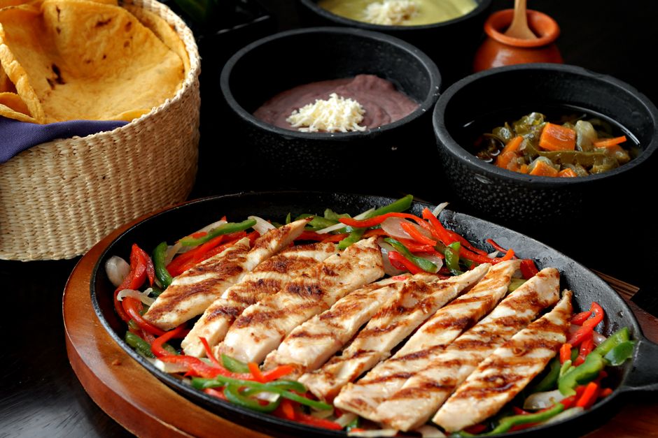 Tasty Mexican grilled chicken fajitas with colorful vegetables, tortillas, and sides, perfect for a savory meal.