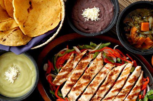 Free Top view of grilled chicken fajitas with tortillas, beans, and sauces, showcasing a vibrant Mexican meal. Stock Photo
