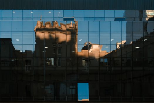 Abstract reflection of a historic building visible in a modern glass facade in Rosario, Argentina.